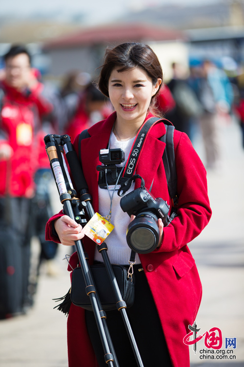2016年兩會，人民大會大堂前，一位笑容燦爛的紅衣女記者正步入大會堂。中國網(wǎng) 鄭亮 攝