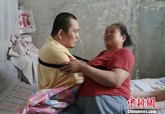 身體日漸衰老的梁青蘭每次幫兒子翻身、坐立，全身的衣物都要濕透一次?！∩忻鱾b 攝