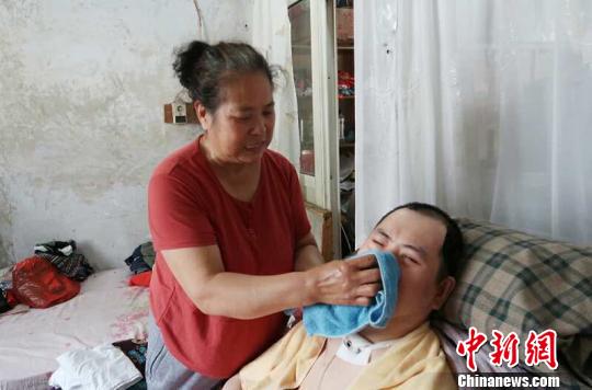 每次喂完食物后，梁青蘭都要仔細(xì)地幫兒子清理干凈?！∩忻鱾b 攝