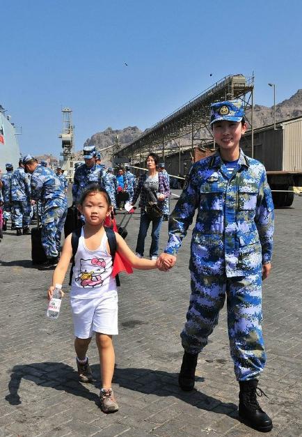 2015年3月，也門，海軍女戰(zhàn)士牽著一名小女孩的手準備登上軍艦。