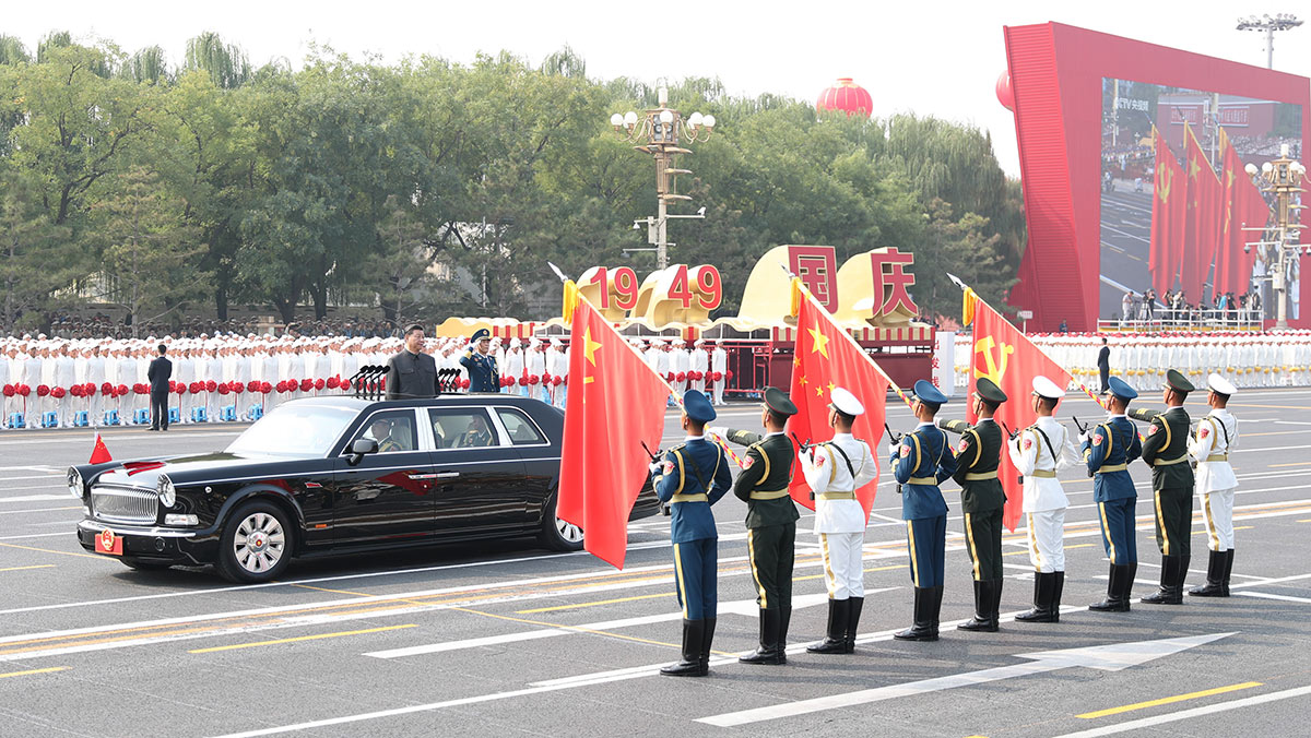 習近平驅(qū)車行進至黨旗、國旗、軍旗前，向旗幟行注目禮