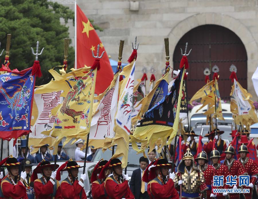 7月3日，韓國總統(tǒng)樸槿惠在青瓦臺(tái)總統(tǒng)府舉行隆重儀式，歡迎中國國家主席習(xí)近平對韓國進(jìn)行國事訪問。這是習(xí)近平的車隊(duì)在身著民族服裝的韓國禮儀隊(duì)伍引導(dǎo)下駛?cè)肭嗤吲_(tái)。新華社記者丁林?jǐn)z  